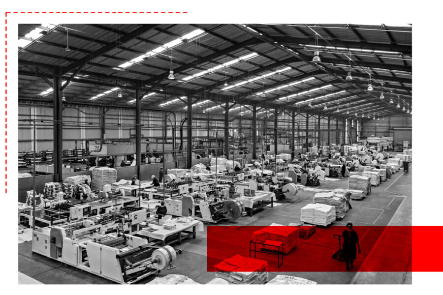 Factory workers handling polywoven material rolls in South African manufacturing facility
